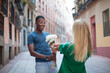 © luisrojasstock - Woman giving a bouquet of white flowers to a man in the street