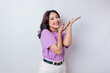 © Reezky - Excited Asian woman wearing lilac purple t-shirt pointing at the copy space upside her, isolated by white background