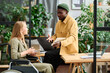 © pressmaster - Young businessman with tablet explaining his colleague in wheelchair online information while sitting on desk in front of her