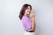 © Reezky - Smiling beautiful Asian woman pointing finger to empty space beside her isolated white background