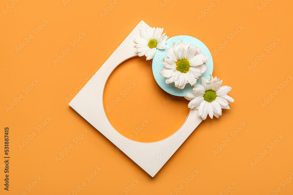 Plaster podiums and chrysanthemum flowers on color background