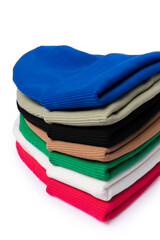 Wall Mural - Close up of stack of insulated stylish beanie hats in bright colors isolated on white. Vertical photo