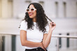 Beauty, fashion and sunglasses with woman in city outdoor for vision, cosmetics or travel. Summer, motivation and makeup with young female influencer in urban street for happy, content or lifestyle