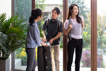 Happy Young Couple Entering Hotel Room With Suitcase
