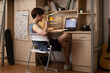 © Blue Jean Images - Young university student using laptop in dormitory