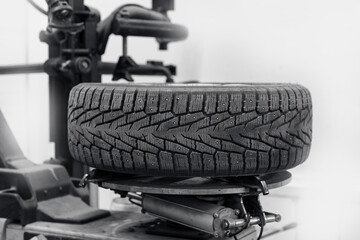 Wall Mural - Concept car wheel service, changing winter tire on machine at station on white background