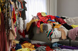 © New Africa - Mess of clothes all over room. Fast fashion