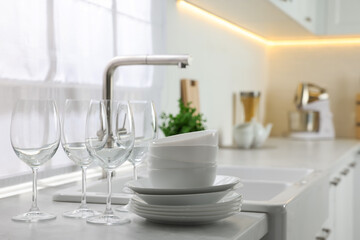 Canvas Print - Different clean dishware and glasses on countertop near sink in kitchen