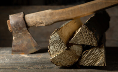 Wall Mural - An ax is cut into a log of firewood for a firebox on a wooden texture