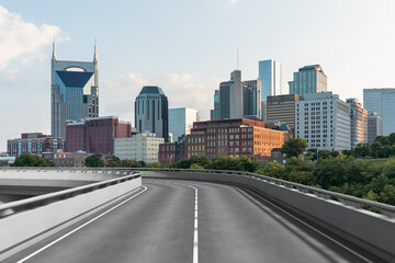 Empty urban asphalt road exterior with city buildings background. New modern highway concrete construction. Concept of way to success. Transportation logistic industry fast delivery. Nashville. USA.