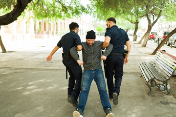 Wall Mural - Police agents bringing a an upset angry homeless man to a shelter