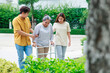 © NVB Stocker - Asian elderly woman used walker for walking. Daughter and husband help  support when walking at green park. Feeling happy.