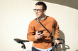 © muse studio - A cyclist uses an app in his phone to go to work with a briefcase. Urban transport.