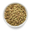 Green lentil in white bowl isolated on white. Top view.