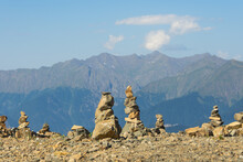 Pyramids Of Stones Is Built On A Mountain Pass. In The Background Beautiful Peaks Of Majestic Mountains.