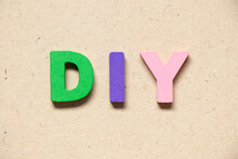 Color Alphabet Letter In Word DIY (abbreviation Of Do It Yourself) On Wood Background