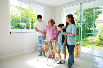 Wall Mural - Happy asian family feel excitement moving to new house, Grandmother using walker , father, mother and daughter support beside her on moving day.