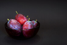 Fresh Plum. Autumn Harvest. Ripe Purple Plums In Glass Bowl On Dark Background. Concept: Seasonal Fruits, Healthy Food. Close Up. Copy Space For Text.