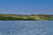 See Loch Ewe mit Bäumen an der Küstenlinie mit blauem Himmel, Blick vom Inverewe Garden, bei Poolewe, Achnasheen, Highland, Schottland	