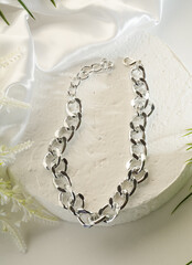 Wall Mural - Fashion bijouterie - large silver chain bracelet on a white stand