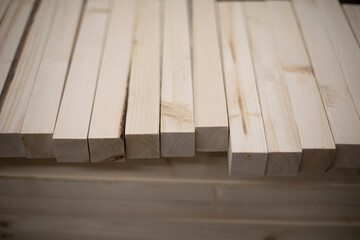 Boards in stock. Wooden blanks. Bars made of wood of light color.