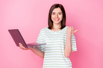 Poster - Photo portrait of nice young girl hold netbook pfinger point empty space dressed stylish striped garment isolated on pink color background