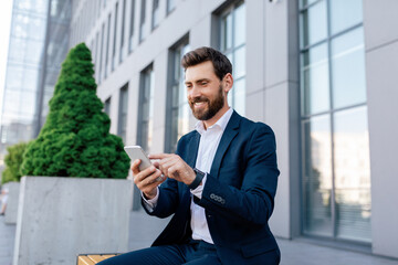 Wall Mural - Businessman at conference outdoor. Happy confident attractive young caucasian male with beard in suit