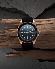 Wall Mural - Luxurious golden watch. Black strap watch on a beautiful piece of wood, advertising of a watch for men and women.
