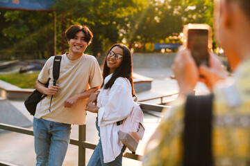 Wall Mural - Young handsome smiling asian boy and beautiful african smiling girl