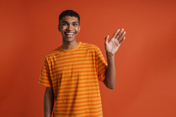 Young handsome smiling happy african man with piercing waving