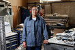 © Seventyfour - Waist up portrait of smiling female worker standing in industrial workshop and looking at camera with confidence