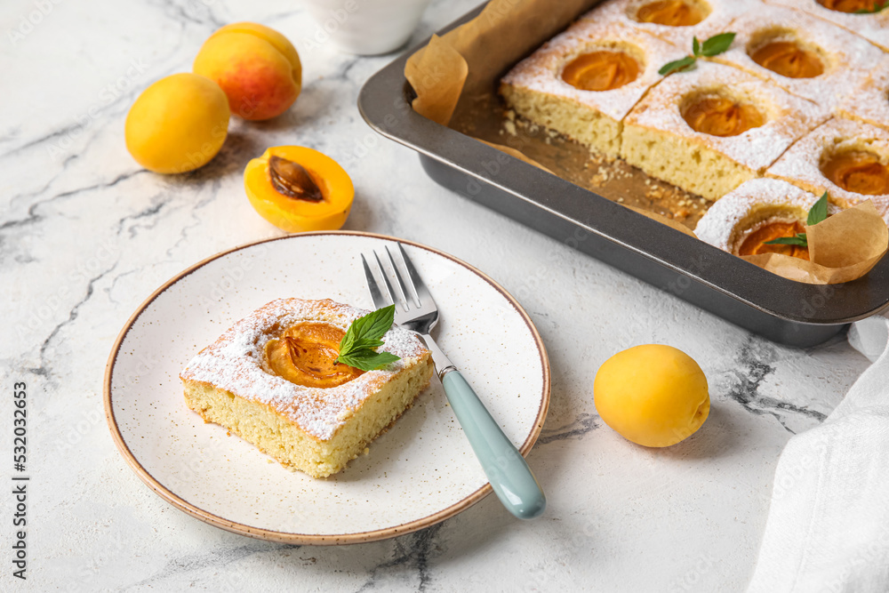 Plate with delicious apricot pie on light background