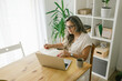 © STUDIO TAURUS - Caucasian woman sitting and writing in notebook at home