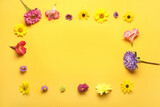 Fototapeta Lawenda - Frame made of bright autumn flowers on yellow background
