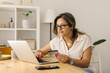 © STUDIO TAURUS - Boomer female shopping online via laptop at home