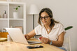 © STUDIO TAURUS - Boomer female shopping online via laptop at home