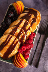 Wall Mural - Pancakes with fruits, berries, chocolate sauce and coconut chips