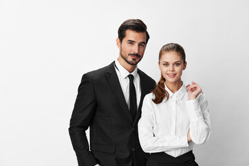 Wall Mural - Man and woman smile with teeth business in business attire looking into camera on white isolated background. Stylish business concept paired between employees startup copy place