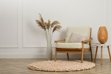 Canvas Print - Stylish armchair with cushion, spikes and lamp near white wall indoors, space for text. Interior design