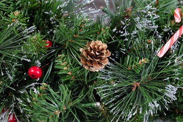 Canvas Print - Artificial Christmas tree with a single gold pine cone and other traditional decorations for a holiday season