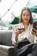© StockPhotoRepublic - Close up photo of young asian beautiful female lady making a payment for an online shopping purchase via her smart phone easily and successful while sitting in a cafe