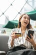 © StockPhotoRepublic - Close up photo of young asian beautiful female lady making a payment for an online shopping purchase via her smart phone easily and successful while sitting in a cafe