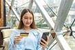 © StockPhotoRepublic - Young asian beautiful female lady making a payment for an online shopping purchase via her smart phone easily and successful while sitting in a cafe