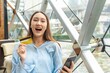 © StockPhotoRepublic - Young asian beautiful female lady making a payment for an online shopping purchase via her smart phone easily and successful while sitting in a cafe