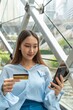 © StockPhotoRepublic - Young asian beautiful female lady making a payment for an online shopping purchase via her smart phone easily and successful while sitting in a cafe
