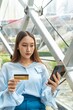 © StockPhotoRepublic - Young asian beautiful female lady making a payment for an online shopping purchase via her smart phone easily and successful while sitting in a cafe
