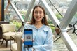 © StockPhotoRepublic - Portrait photo of a beautiful young asian businesswoman lady holding her smartphone showing a QR code to accept payment and to make a payment transaction wirelessly