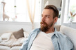 Leinwandbild Motiv Bearded smiling handsome young man portrait alone at home
