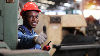 Technician engineer and worker in protective uniform standing and holding walkie talkie and showing thumb up after controlling operation checking industry machine process at industry manufacturing