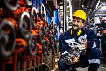 Wall Mural - Heating plant worker changing industrial pipe valves as regular maintenance process.